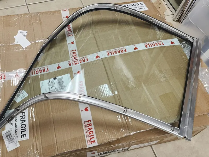 Curved windshield panel in its aluminum frame